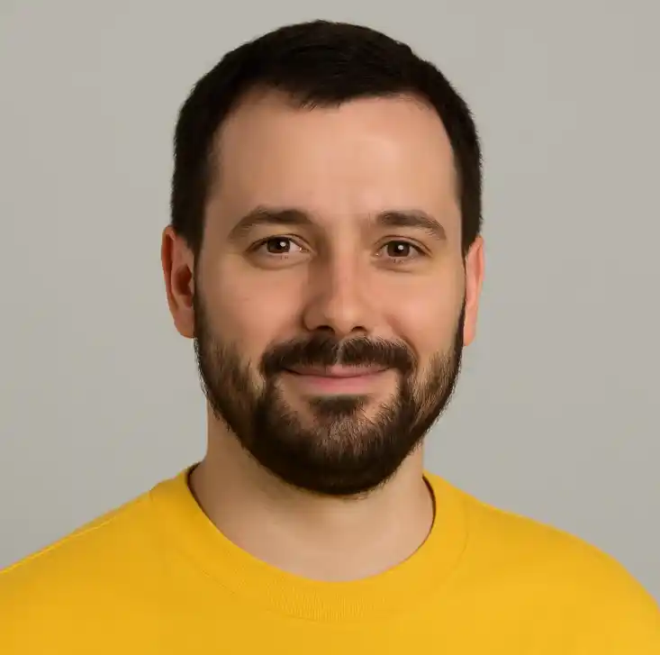 Portret uśmiechniętego mężczyzny w żółtej koszulce z ciemnymi włosami i brodą